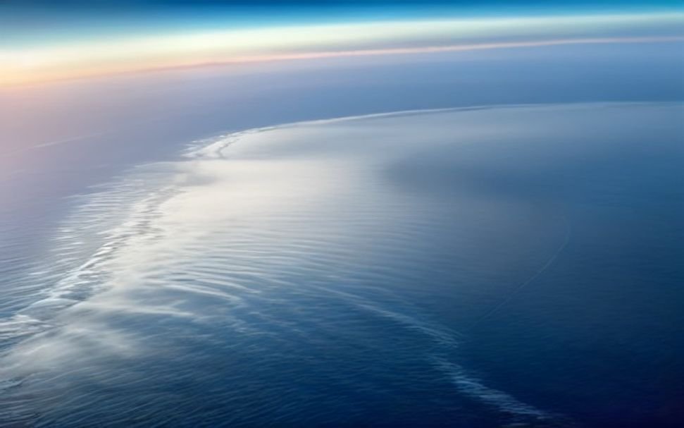 Battery-electric aircraft flying at sunrise over ocean — green technology breakthroughs 2026
